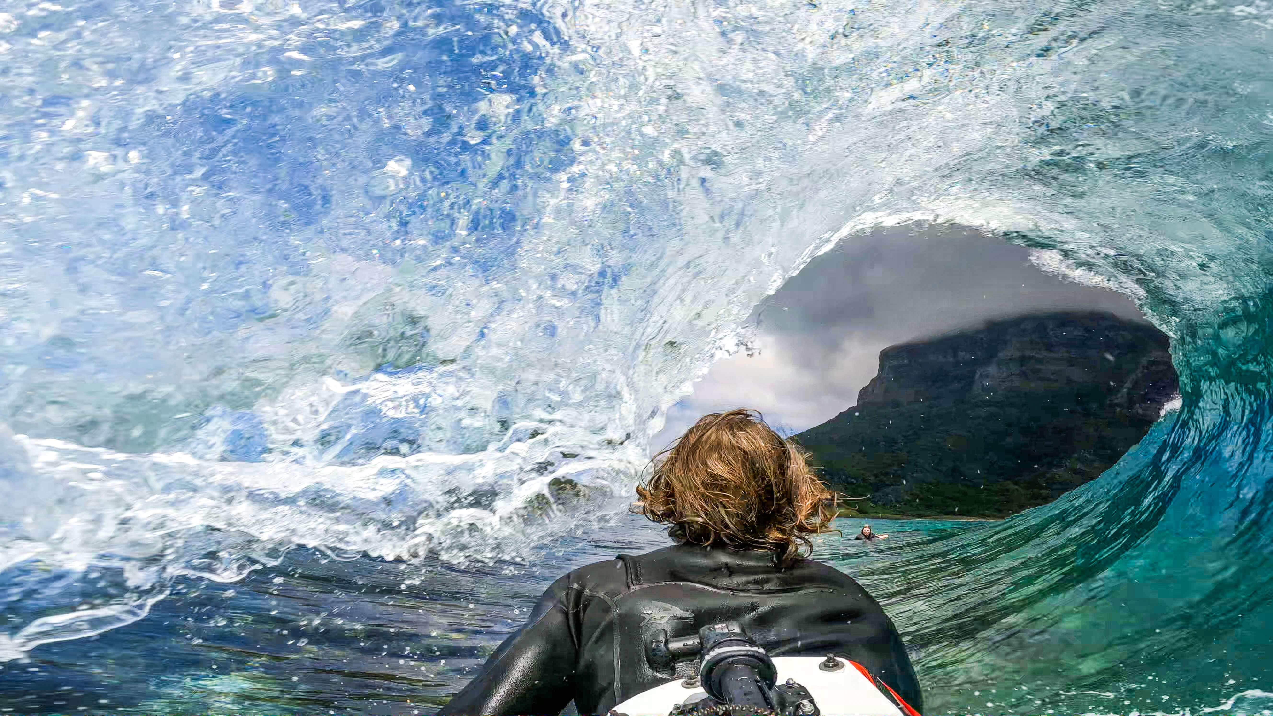 Surfer travelling through wave