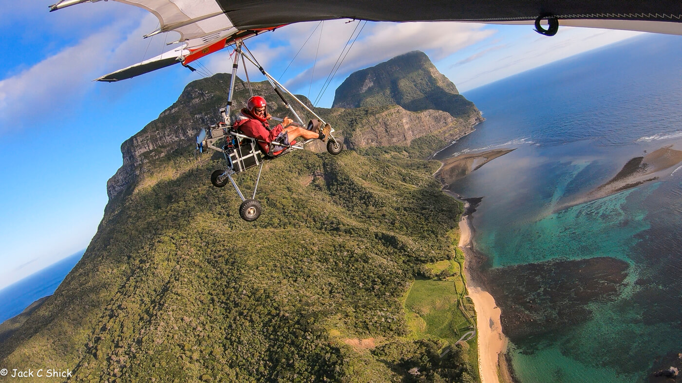 Hang glider over mountains and ocean